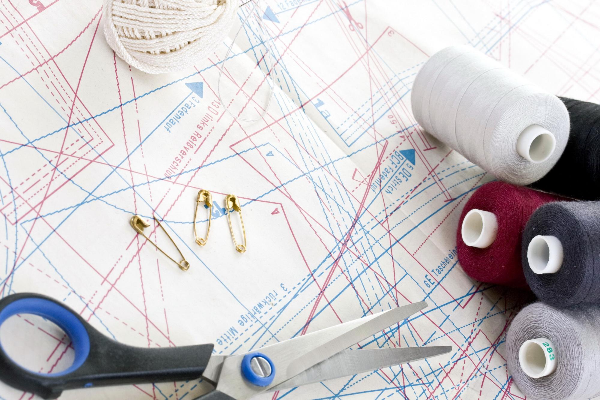 Workshop table with threads, patterns and a modern embroidery machine